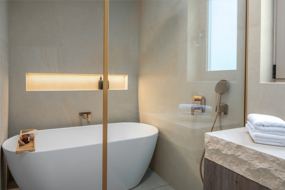 An en-suite bathroom with a bathtub, a shower, a sink, and a toilet