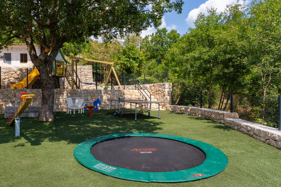 Equipped children's playground with trampoline, slide and playhouse.