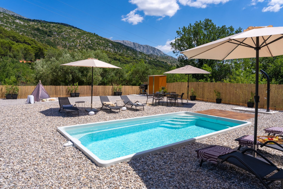 The outdoor area also offers an outdoor shower, 3 sun umbrellas, and a corner for children equipped with a tent and toys