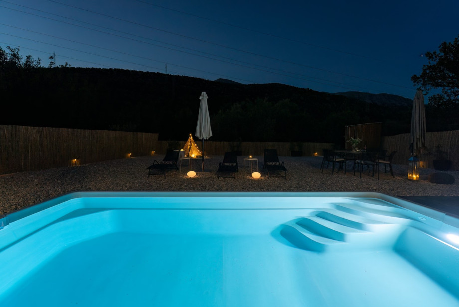 In the evening, the illuminated pool creates a peaceful and inviting atmosphere, perfect for a relaxing swim or unwinding under the stars.