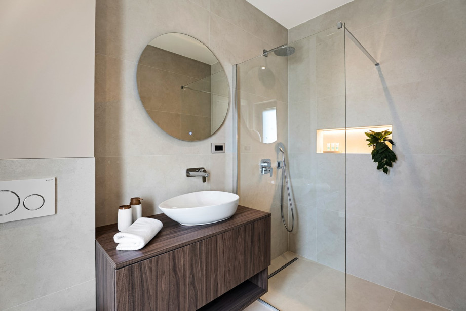 An en-suite bathroom with a shower, a sink, and a toilet