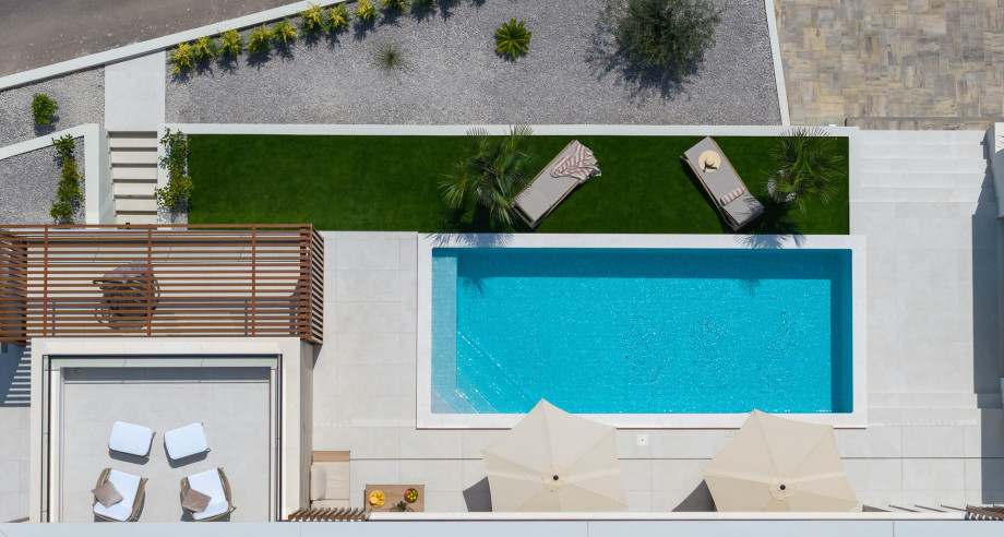 A spacious terrace with outdoor furniture offers amazing sea and pool views