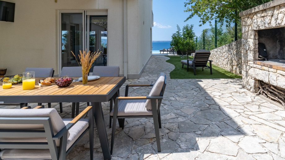 ust behind the sundeck area is a covered outdoor dining area with a barbecue