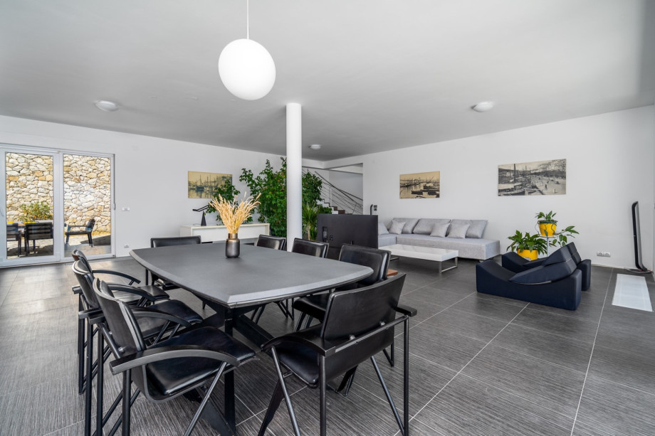Dining table, a glass door toward the pool on one side, and an outdoor dining area on the other side.