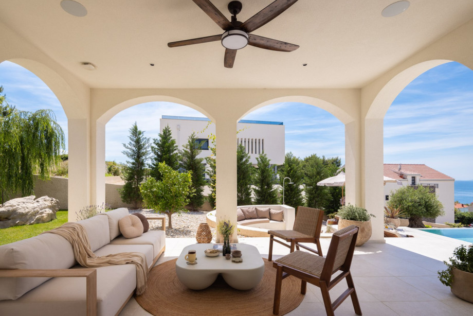 A few steps up is a covered, comfortable lounge corner, a perfect spot for a morning coffee