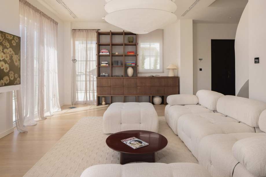 The living room boasts plush sofas, a flat-screen TV, and high-speed WiFi