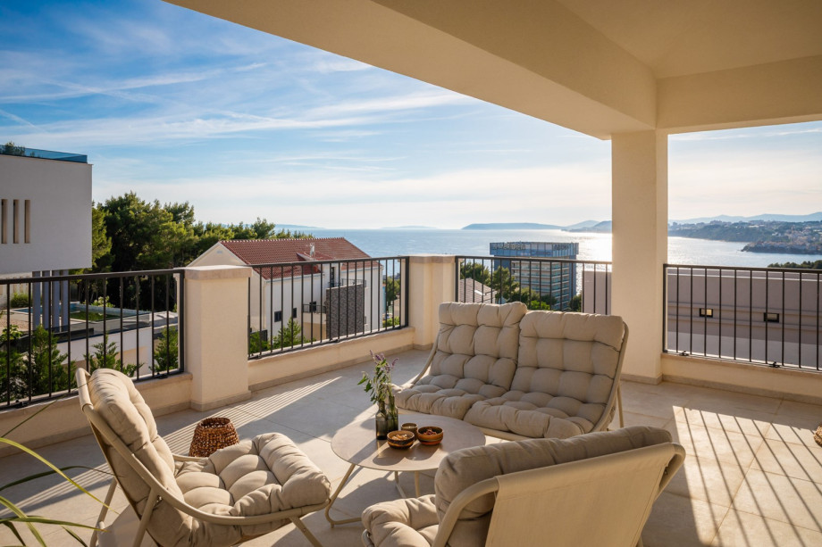 A terrace with a lounge corner overlooking the pool and the town of Split