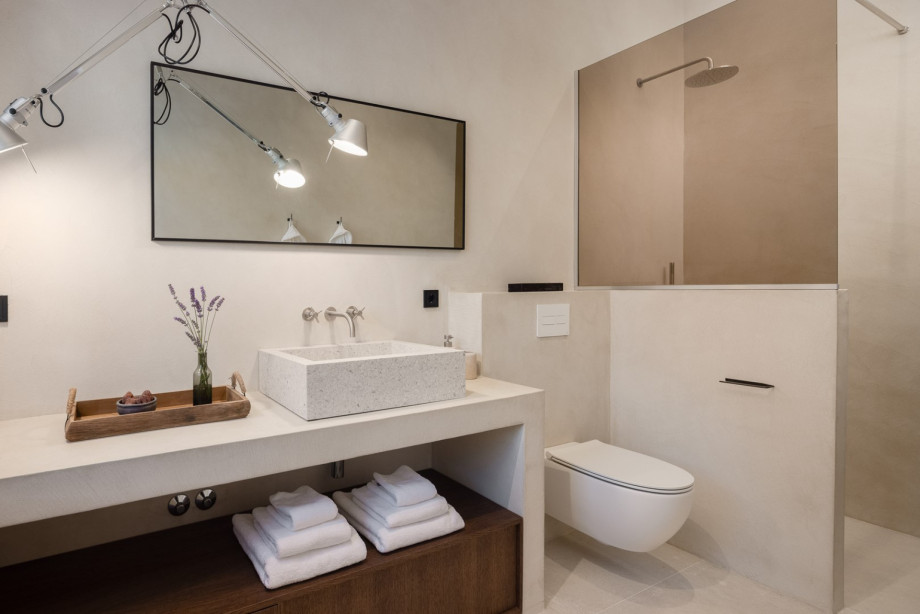 An en-suite bathroom with a shower, a sink, and a toilet