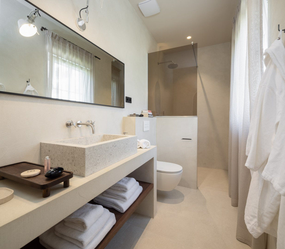 An en-suite bathroom with a shower, a sink, and a toilet