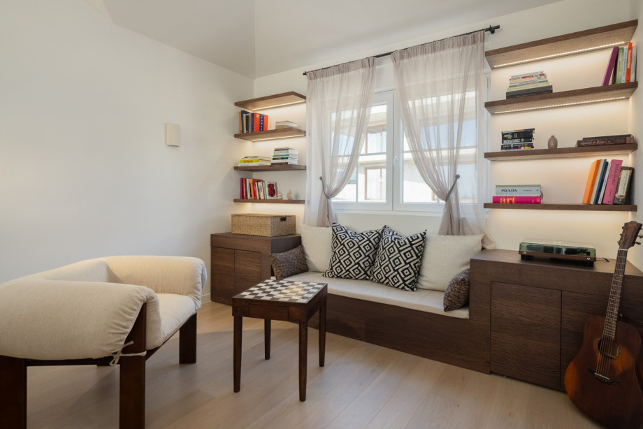 A cozy reading and relaxation room, stocked with books and games like chess, creates a quiet retreat within the villa