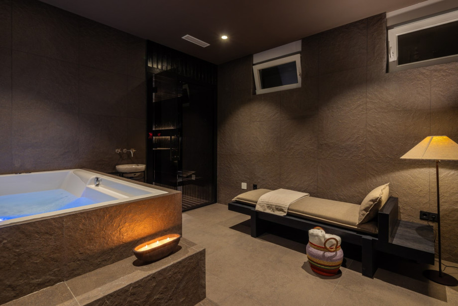 Featuring a Finnish sauna, a whirlpool, relaxing deck chair, and a walk-in shower complemented by a separate toilet