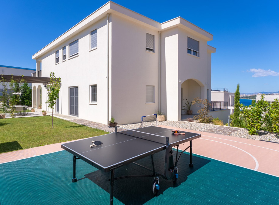Enjoy a lush grass lawn for outdoor relaxation, with a table tennis table located nearby for friendly games and extra fun