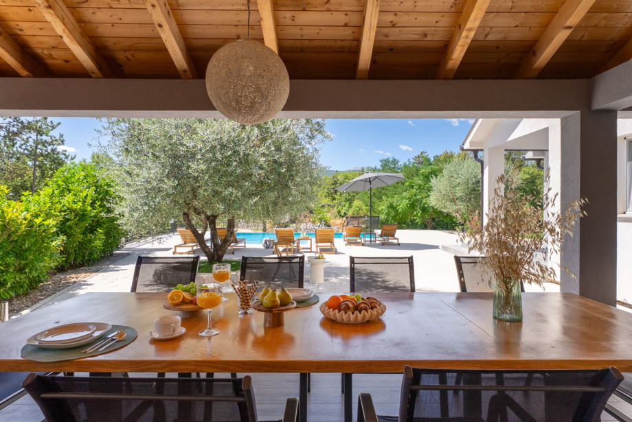 The 50 sqm summer kitchen is fully equipped with an electric hub, oven, and a dining table for 10 people.