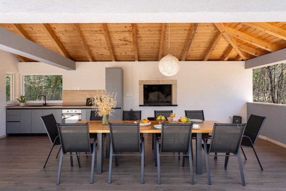 The charming summer kitchen features a barbecue area for wood or charcoal grilling and an outdoor dining space.