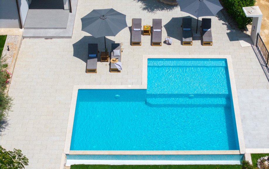 Sun deck around the pool with six comfortable loungers and umbrellas.