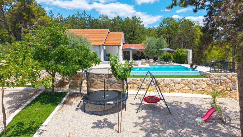 The villa features a swing and slide for children to enjoy.