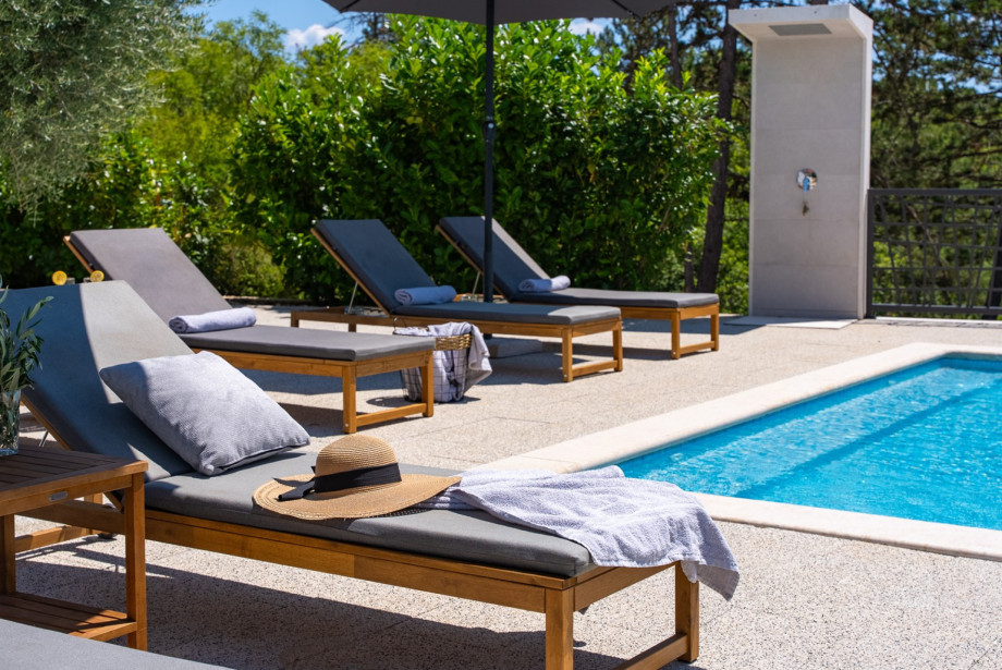 Sun loungers and an outdoor shower right by the pool deck.