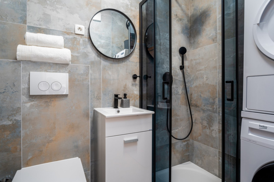 Bathroom with a shower, washing machine, and a dryer