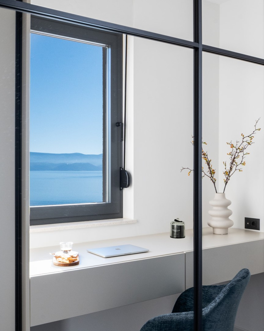 Ein stilvolles Büro mit einem Bürotisch, einem Stuhl und spektakulärem Meerblick