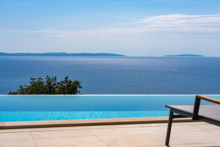 The heated infinity pool of 41.5 sqm offers breathtaking panoramic sea views.