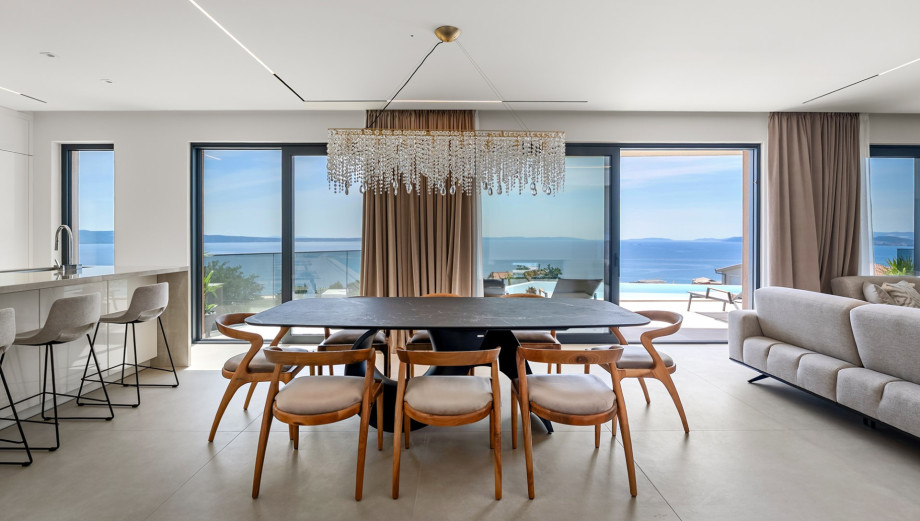 Main dining table positioned between the fully equipped kitchen and living lounge.