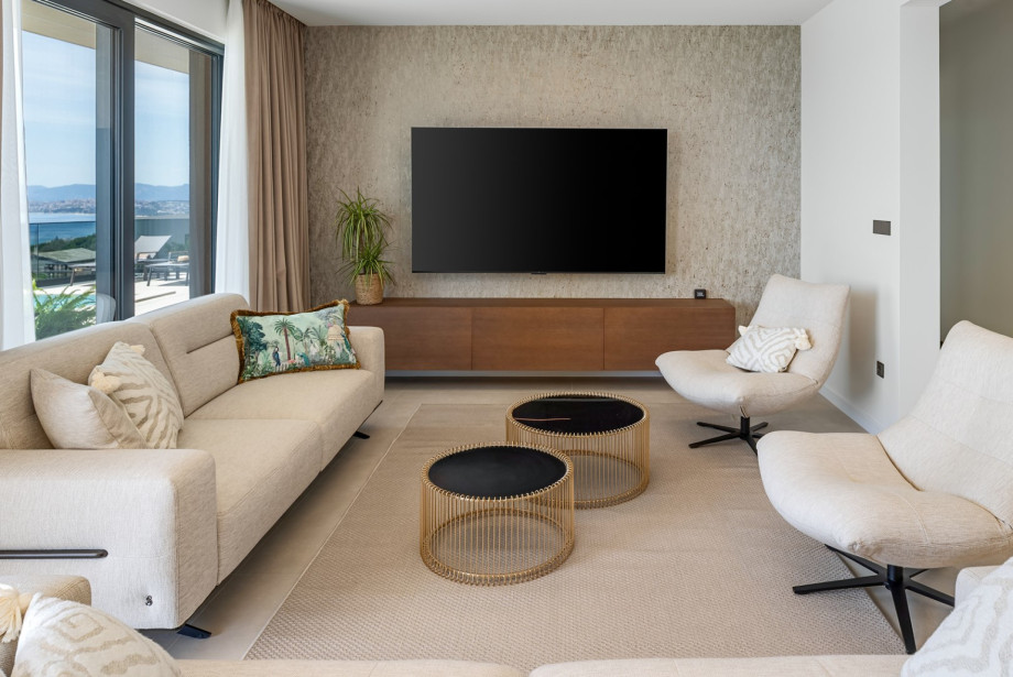 Air-conditioned living space equipped with a flat-screen TV and pool access.