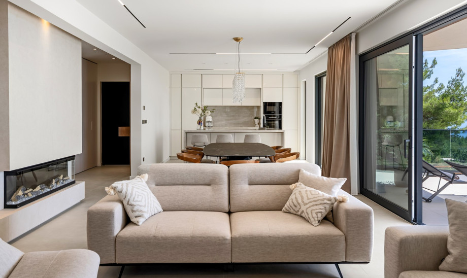 Fully furnished main living zone combining a sofa lounge, TV, and fireplace.