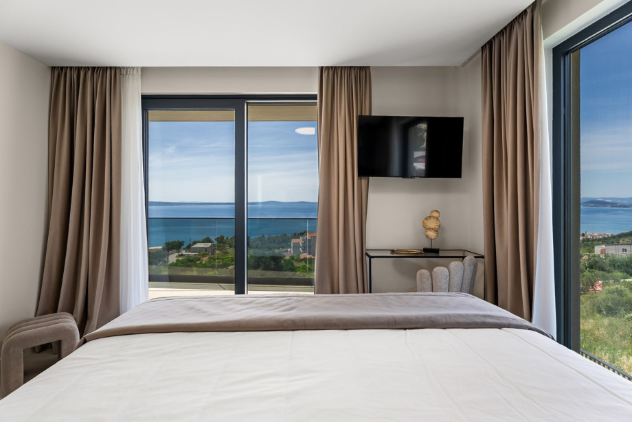 Bedroom setup with a king-size bed and direct access to a balcony.