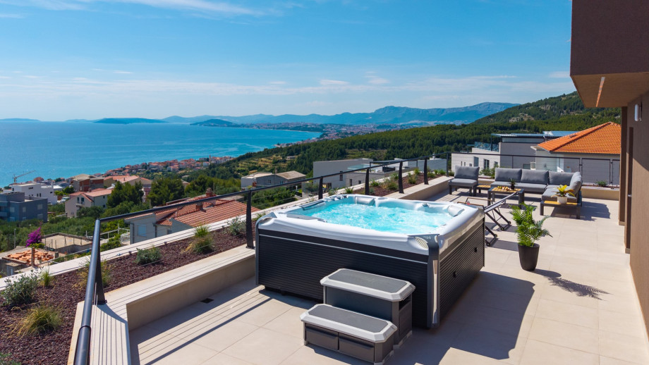 Top-level terrace with a lounge corner and a hot tub.