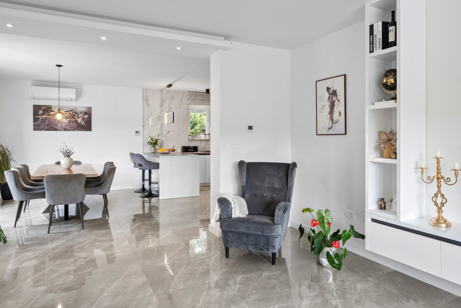 The open-plan design connects the spacious living room seamlessly with the dining area and the fully equipped kitchen on the first floor.