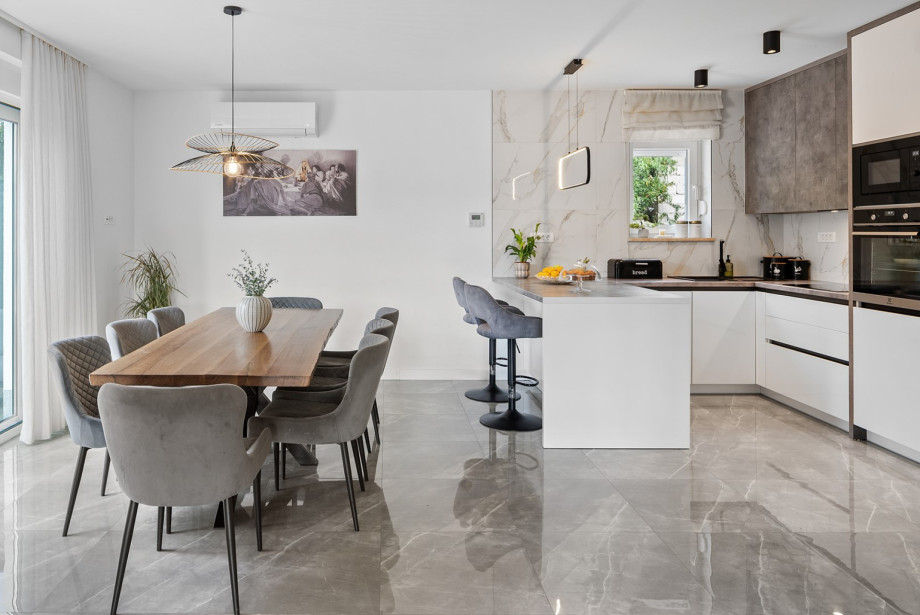 The first floor's fully equipped kitchen features a central kitchen island and a dedicated dining table for enjoyable gatherings.