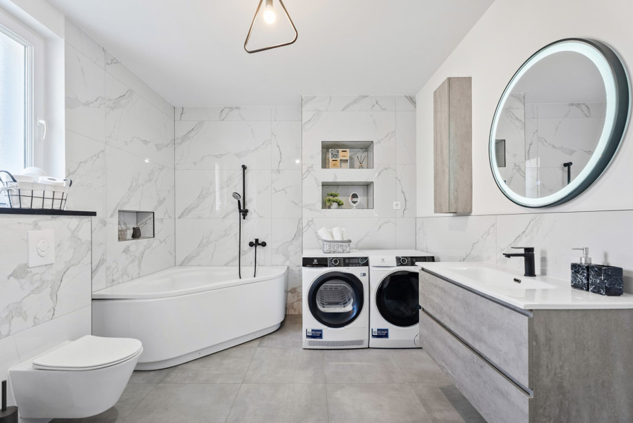 The family bathroom on the first floor features a bathtub, a toilet, a washing machine, and a dryer for guest convenience.