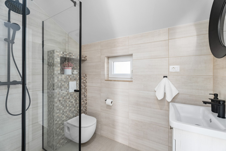 The villa includes 4 bathrooms in total, such as this modern one with a shower and all necessary facilities.