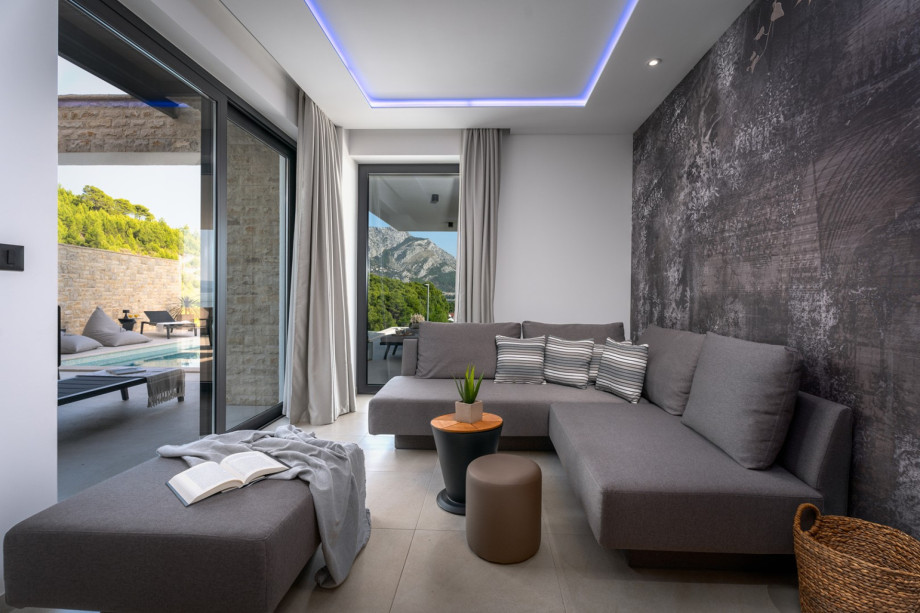 Im Erdgeschoss befindet sich ein Medienraum mit einem Flachbildfernseher, einer PS5, einer Bose-Soundbar, einer Klimaanlage und einem Sofa (das in ein Schlafsofa umgewandelt werden kann).