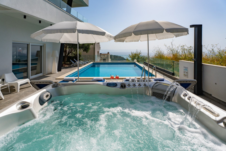 The outdoor area features a private heated 32 sqm swimming pool (6.8 x 4.7 m), a hot tub