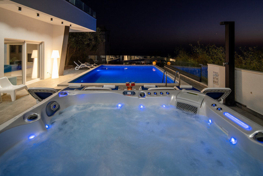The outdoor area features a private heated 32 sqm swimming pool (6.8 x 4.7 m), a hot tub
