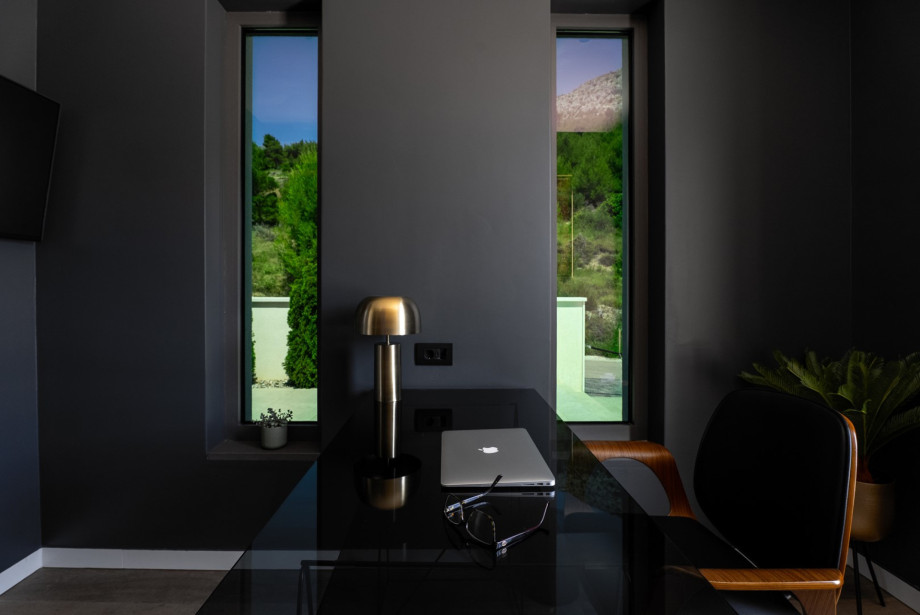 The First floor offers a stylish office with a desk, a chair, and a TV.